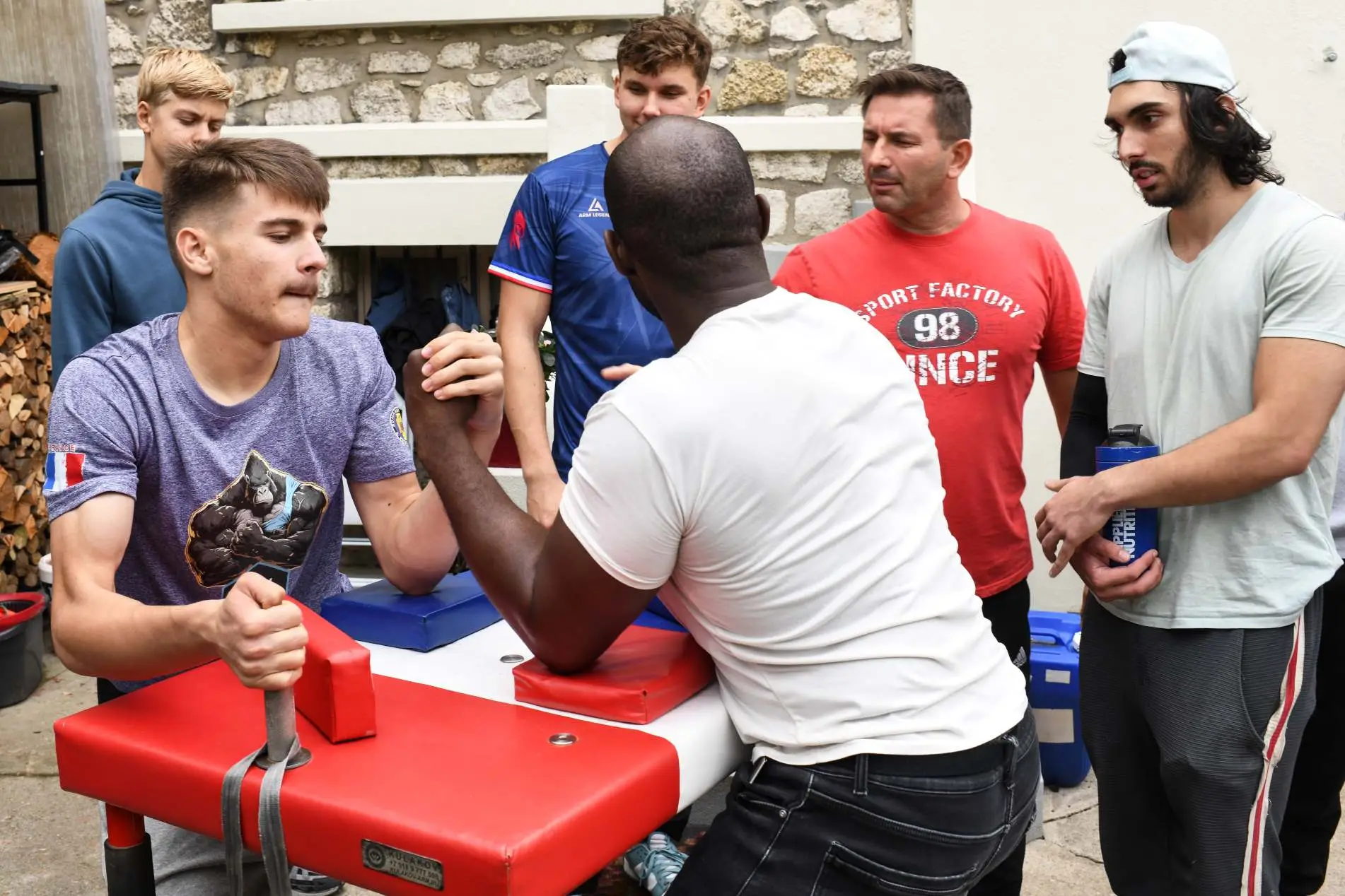 Deux athlètes s’affrontent lors d’un entraînement de bras de fer sportif encadré par le club X-MEN Armwrestling à Paris.